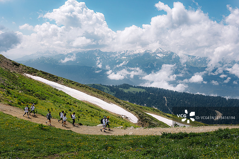 一群徒步旅行者沿着山间的道路行走图片素材