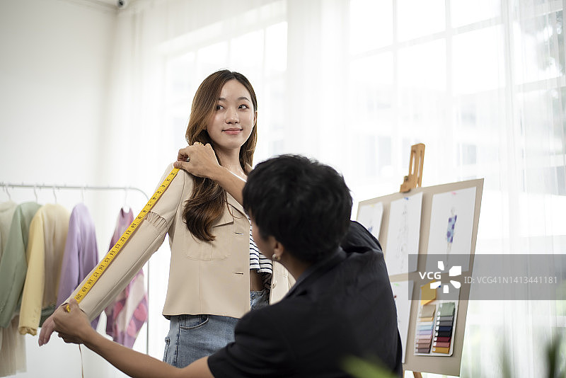 服装设计师正在测量设计尺寸，以设计顾客想要的漂亮衬衫。图片素材