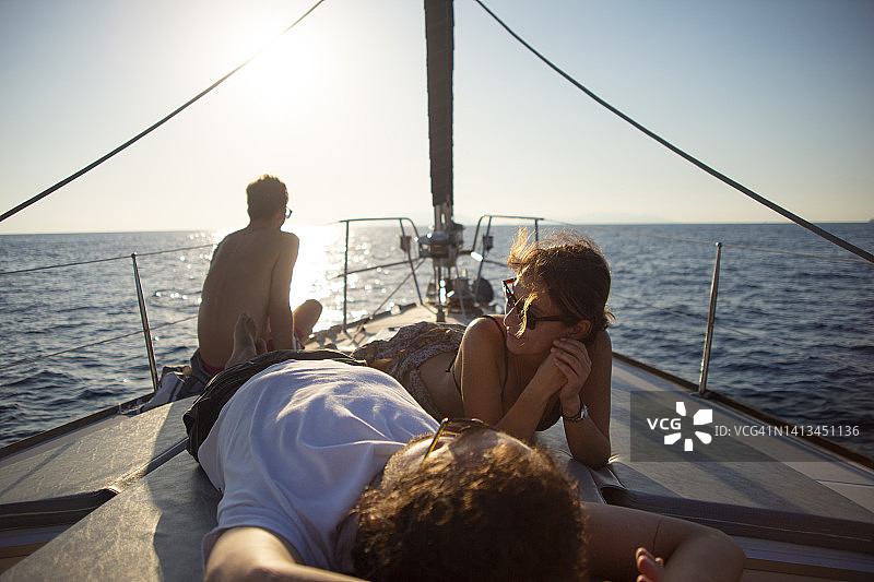 朋友在帆船甲板上放松，午后阳光图片素材
