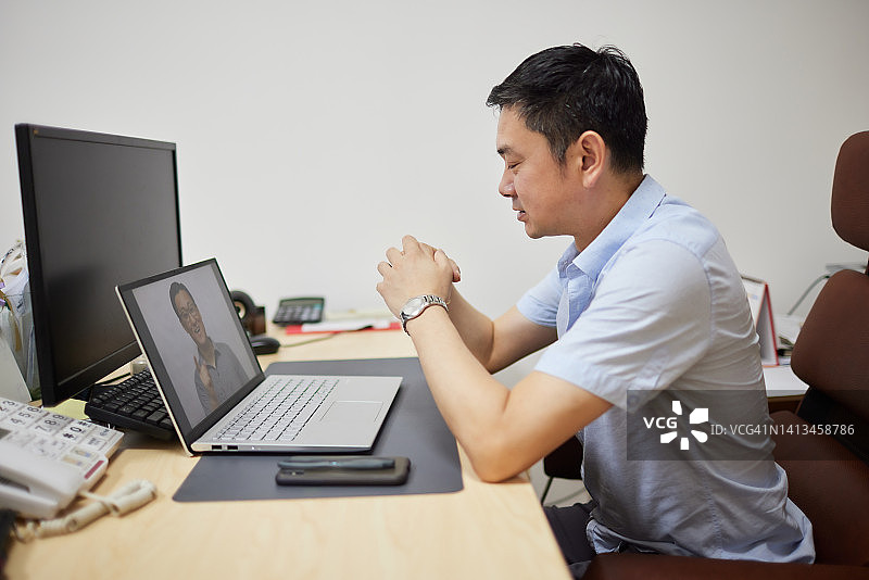 男人在办公室用笔记本电脑与客户进行视频会议图片素材
