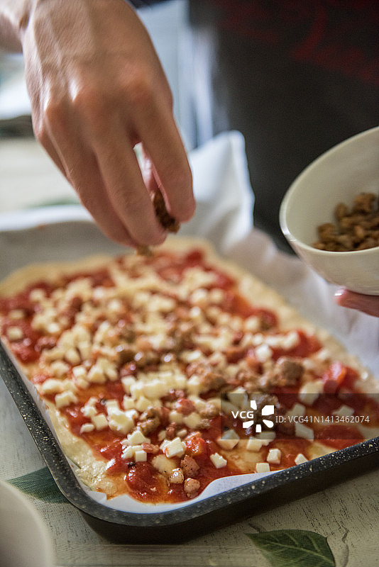 在四种奶酪披萨上添加香肠片图片素材