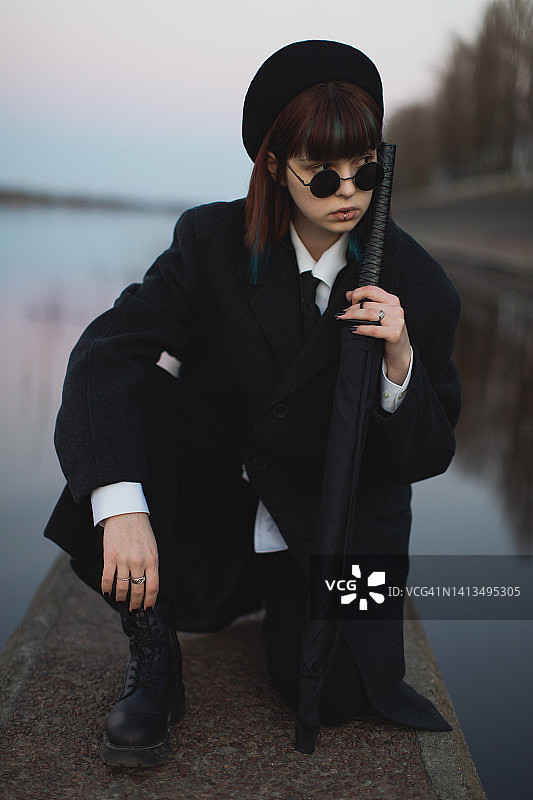 日落背景下穿黑色衣服的红发女孩，哥特风格图片素材