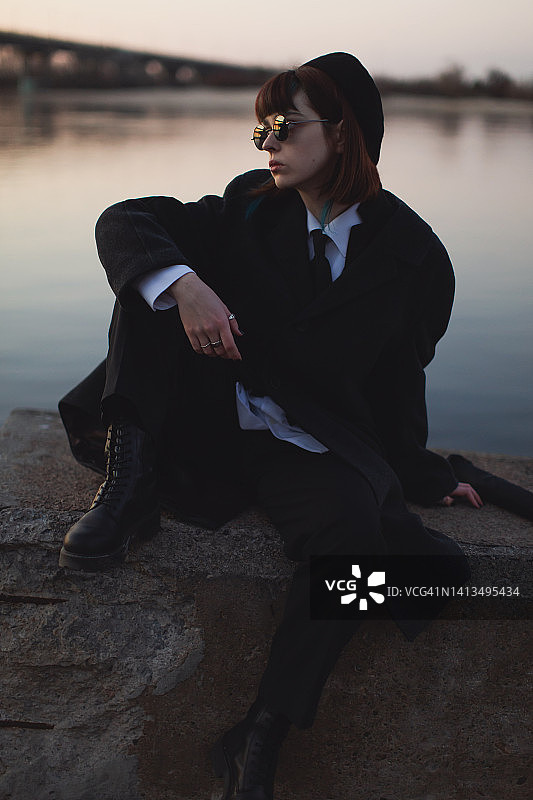 户外河流背景下的黑衣红发女孩图片素材