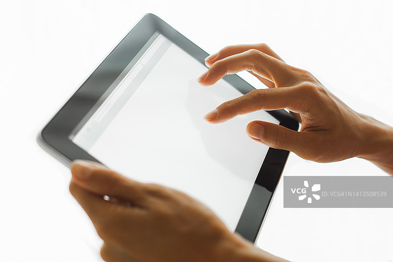 手持触摸屏平板电脑。空白白色复制空间背景。图片素材