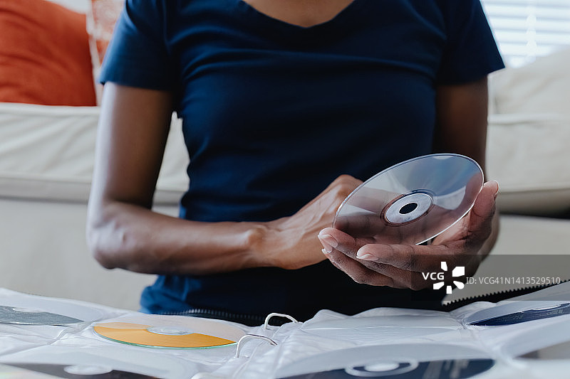 女人从她的收藏中选择CD图片素材