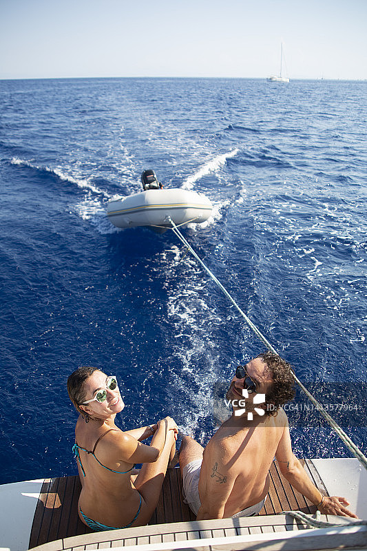 朋友们坐在帆船尾部，转身看向镜头图片素材