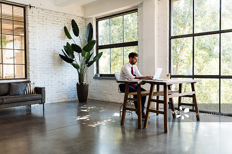 在办公室使用笔记本电脑参加视频会议的商人图片素材