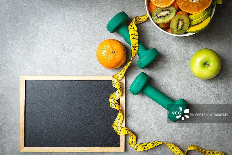 饮食：健康饮食和生活方式概念。运动锻炼、新鲜水果和卷尺，塑造健康身材。图片素材