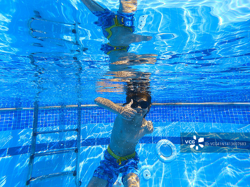 小男孩在泳池里水下游泳图片素材