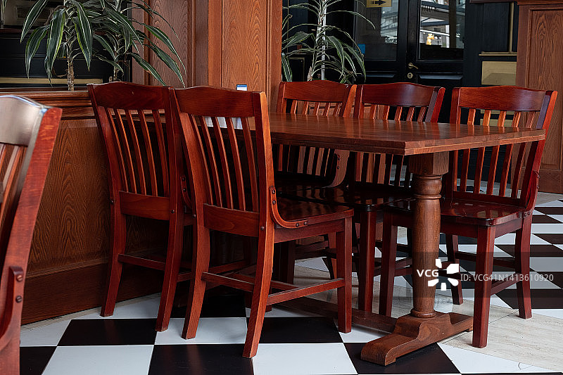空荡荡的咖啡馆、办公室、共享办公空间或房间内的木制桌椅，时尚的设计，复古风格，因疫情和冠状病毒而关闭的餐厅图片素材