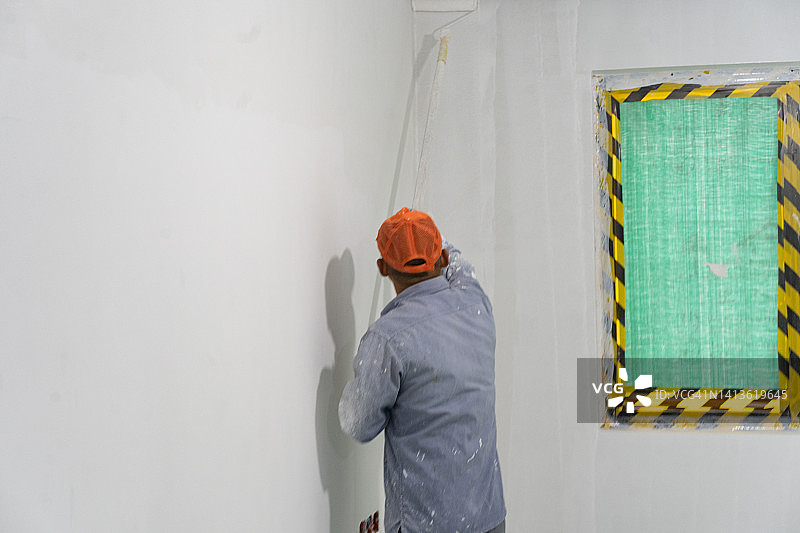 粉刷墙壁的亚洲师傅图片素材