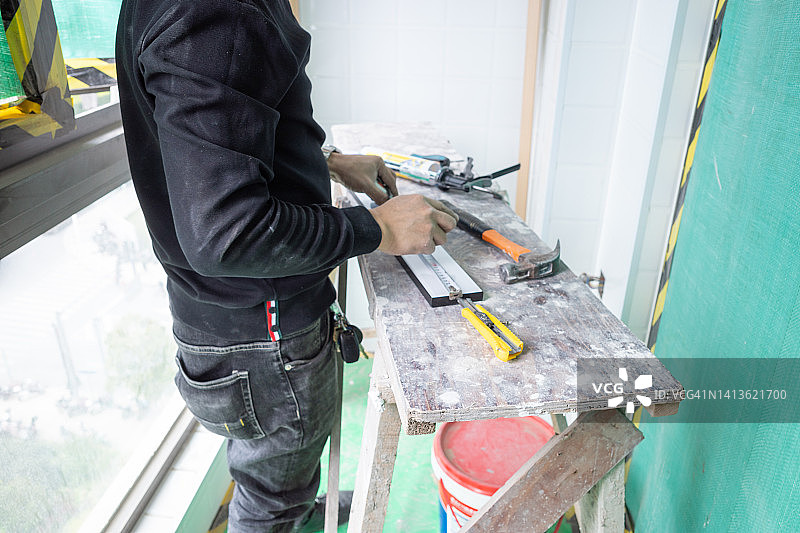 一名亚洲男子正在测量切割家具的配件图片素材