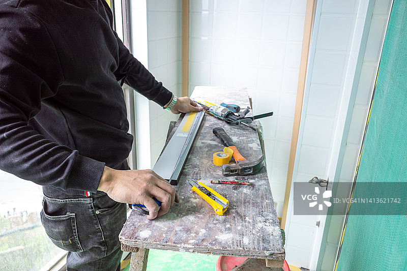 一名亚洲男子正在测量切割家具的配件图片素材