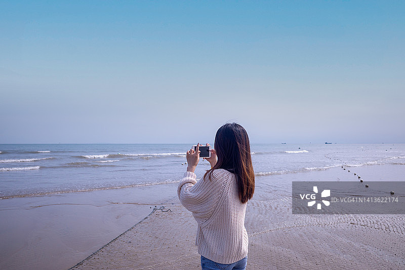 年轻的亚洲女性在海边拍摄大海图片素材