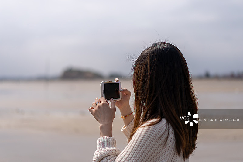 年轻的亚洲女性在海边拍摄大海图片素材