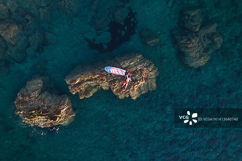 躺在海边岩石上的男子图片素材