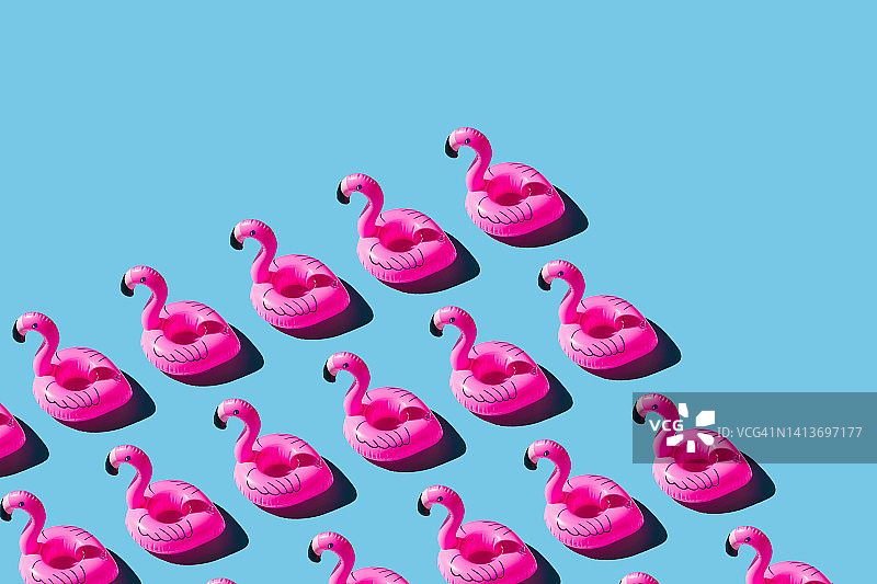 蓝色背景上的粉色充气火烈鸟图案图片素材