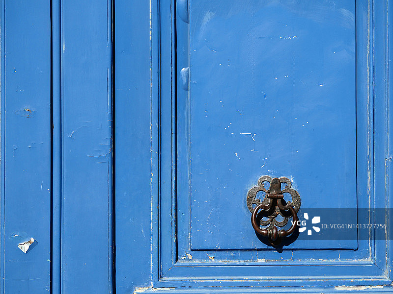 法国巴黎，蓝色木门和金属门环特写图片素材