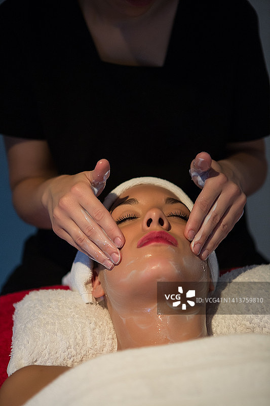 美容师在美容院为女顾客面部按摩特写图片素材