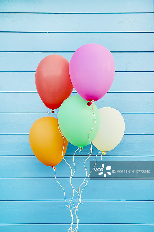 蓝色木墙上的彩色气球图片素材