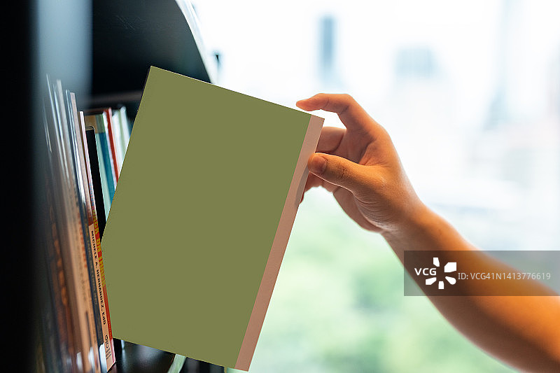 手从书架上取出一本书图片素材