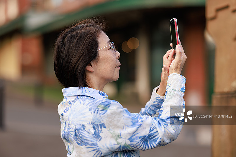 微笑的女人用手机拍照图片素材