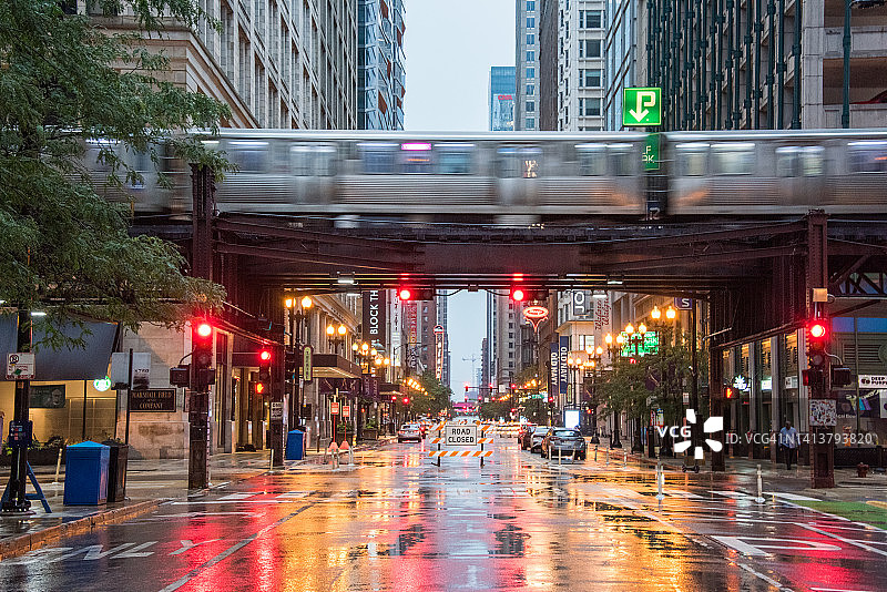 芝加哥L线列车与彩色交通信号灯在湿路上的倒影图片素材