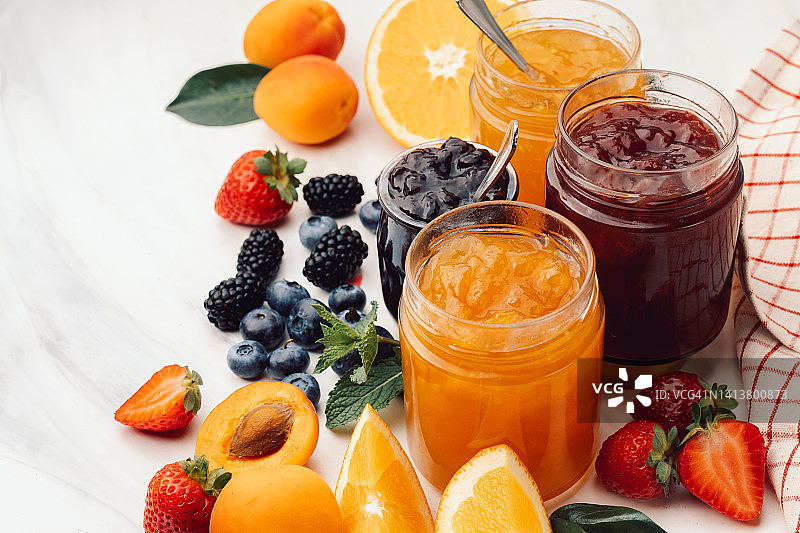 白色桌子上玻璃罐中的自制果酱图片素材