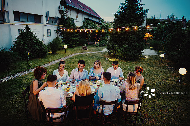 男子在户外与亲友聚餐时发言图片素材