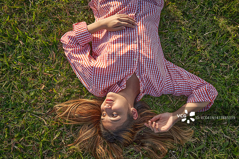 穿着红色衬衫观看的年轻漂亮女人图片素材