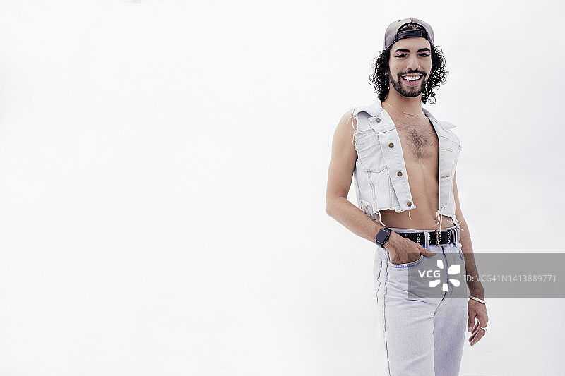 手插在口袋里，站在白色背景下的快乐的人图片素材