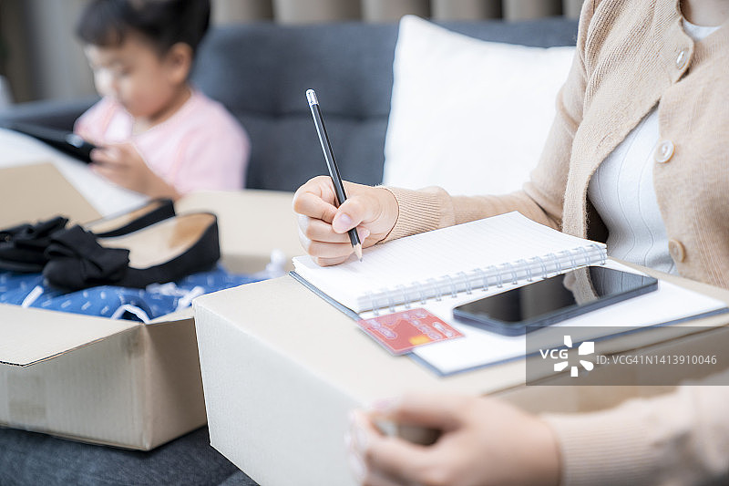 拿着信用卡在家管理个人财务的女人图片素材
