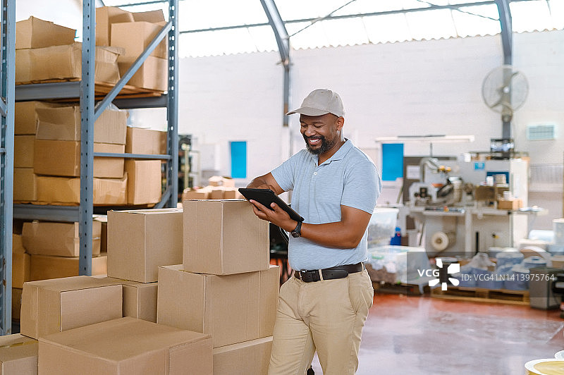 年长的物流经理在仓库中检查平板电脑，进行库存盘点，清点纸箱。工头跟踪进出口批发订单图片素材