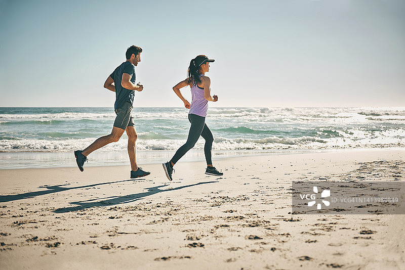 在海滩上锻炼的健康活力情侣图片素材