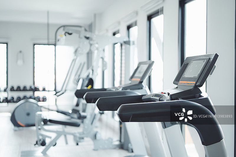 现代健身中心内，一排跑步机图片素材