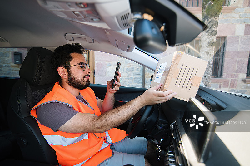 配送员用智能手机扫描包裹标签图片素材