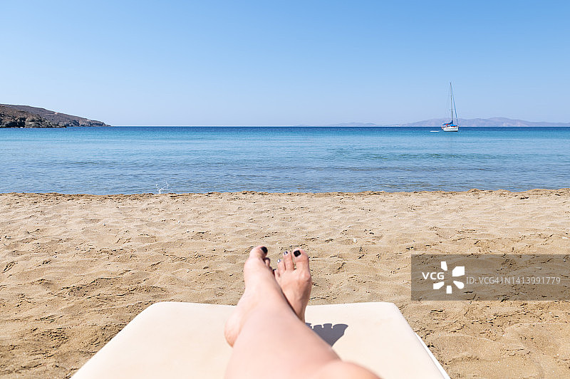 在爱琴海海滩日光浴床上享受日光浴的女人图片素材