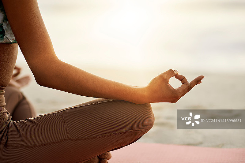 平静放松的女子在海滩莲花座冥想图片素材