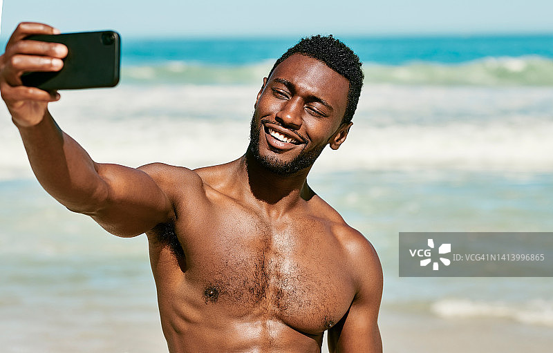 沙滩上自信健壮的黑人男人自拍图片素材