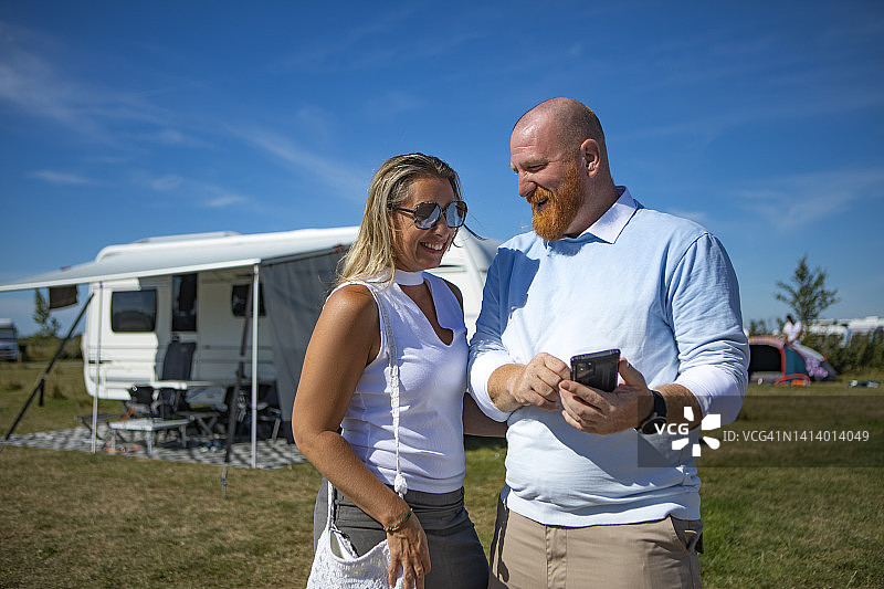红发丈夫和金发妻子在阳光明媚的春天进行房车露营图片素材