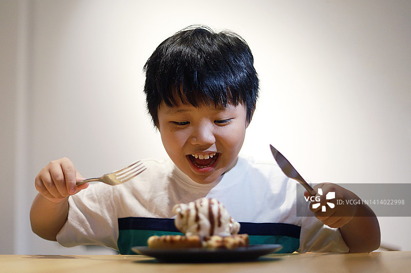 男孩享用美味的华夫饼冰淇淋图片素材