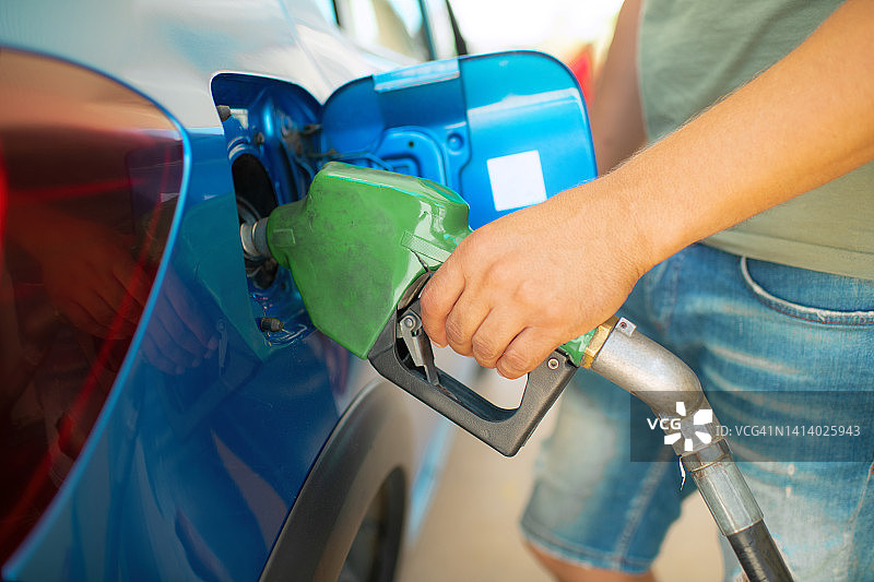 男人在加油站给汽车加油的手图片素材