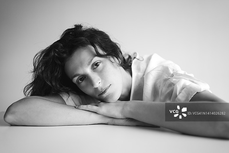 美丽的年轻女子用手托着下巴，黑白摄影图片素材