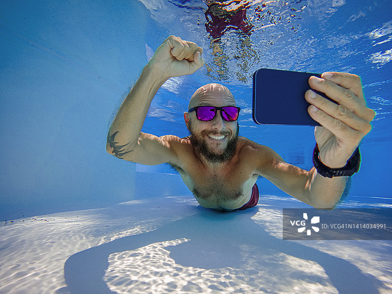 在水下用手机进行在线赌博：游戏成瘾图片素材