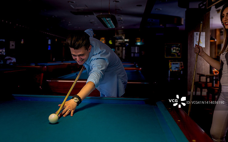 年轻男人在室内俱乐部打台球图片素材