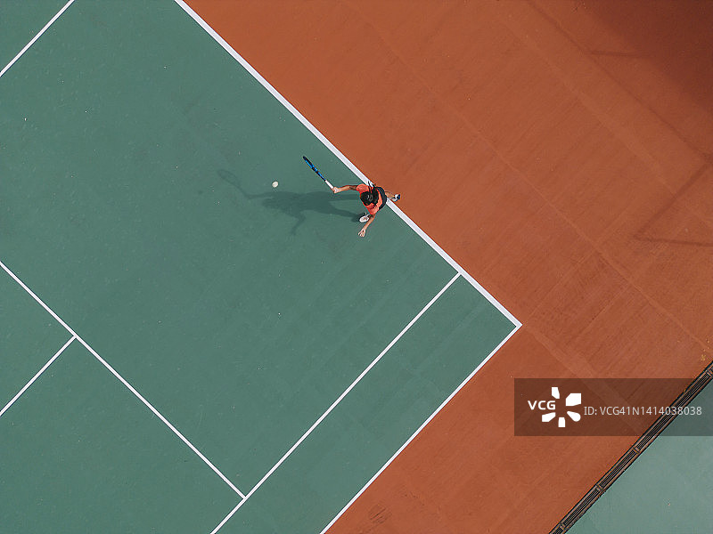 无人机视角：在网球场练习发球的亚裔印度女网球运动员图片素材