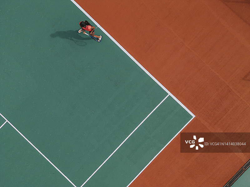 无人机视角：在网球场练习发球的亚裔印度女网球运动员图片素材