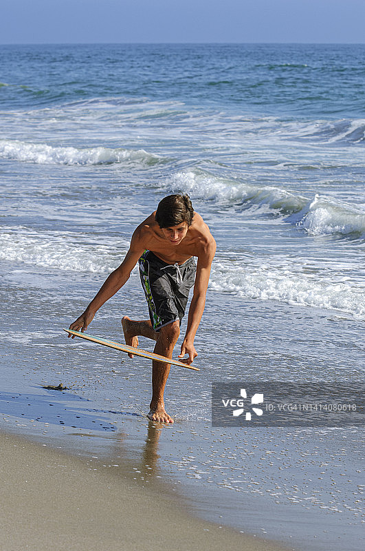 在海浪中玩耍的拉丁裔少年图片素材