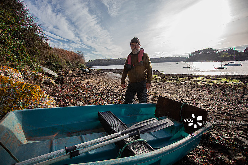 一位水手划着小艇驶向河口图片素材