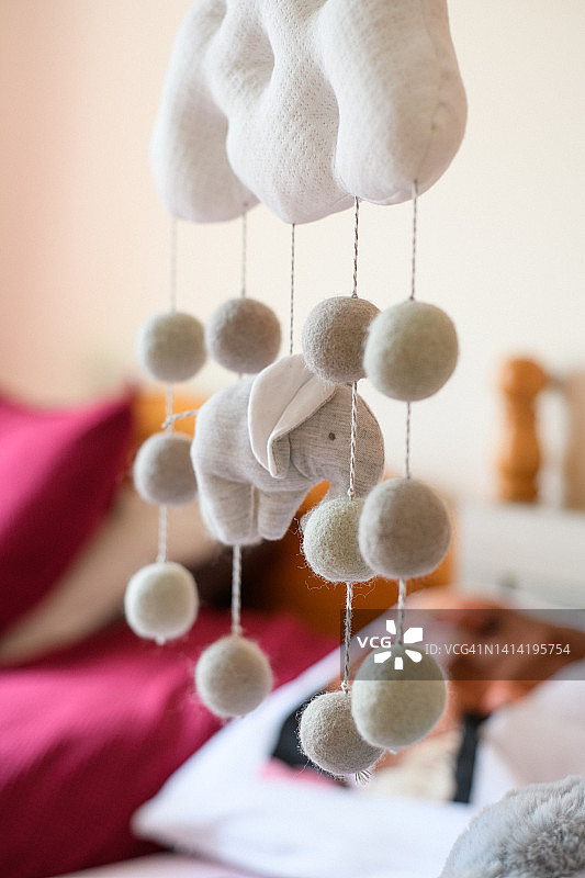 卧室中婴儿床上方悬挂的床铃特写图片素材